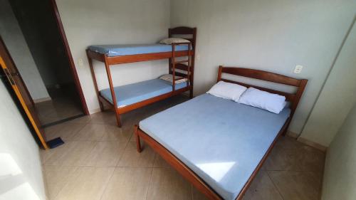 Dormitorio pequeño con cama y estante en Edifício Ferreira - Apartamentos temporadas, en Piúma