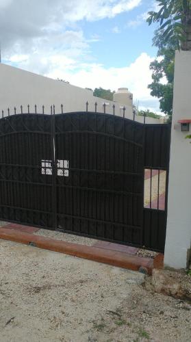 a black fence with a gate in front of a house at Casa Nicte-ha Valladolid in Valladolid