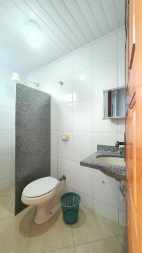 a white bathroom with a toilet and a sink at Edifício Ferreira - Apartamentos temporadas in Piúma