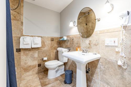 a bathroom with a toilet and a sink and a mirror at Treasure Mountain Inn in Park City