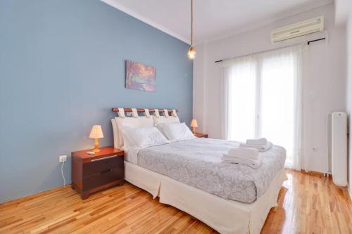 a bedroom with a large bed and a blue wall at Lovingly restored apartment Galatsi in Athens