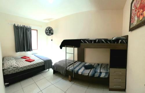 1 Schlafzimmer mit 2 Etagenbetten und 1 Bett in der Unterkunft Apto Aeroporto Macae in Macaé