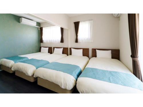 2 camas en una habitación con 2 camas individuales en Bears Stay Kumejima Eef Beach - Vacation STAY 85672v, en Kumejima