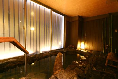 a swimming pool in a room with a large window at Dormy Inn Hakata Gion in Fukuoka