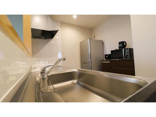 a stainless steel sink in a kitchen with a refrigerator at Bears Stay Kumejima Eef Beach - Vacation STAY 85672v in Kumejima