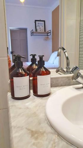 3 bouteilles de savon assises sur un lavabo dans l'établissement Domaine Lapèze, à Montcuq