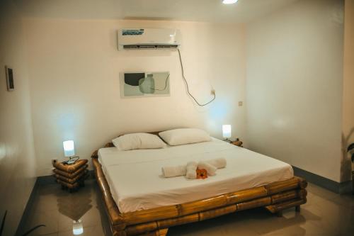 a bedroom with a bed with a teddy bear on it at Skott's Comfy Lodge in Bantayan Island