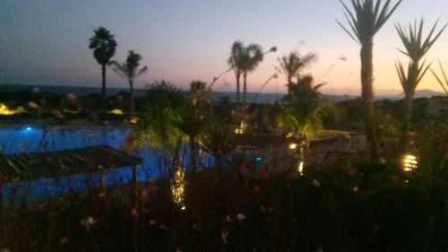 a view of a resort pool at sunset at Casa das Dunas Soltroia in Troia