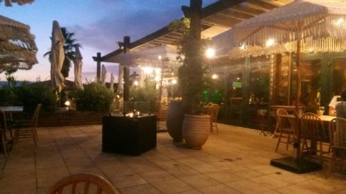 a patio with tables and chairs and a building at Casa das Dunas Soltroia in Troia