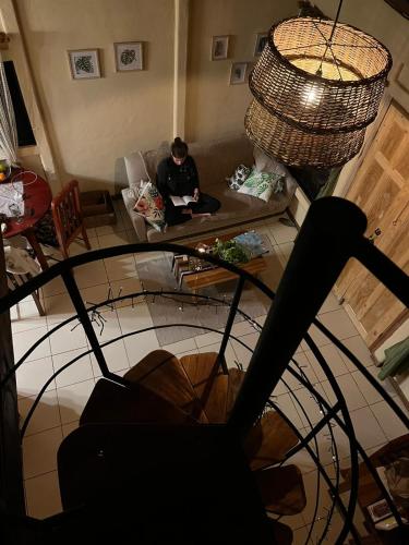 a person sitting on a couch in a living room at Greenhouse Lofts Miravalles in Aguas Claras