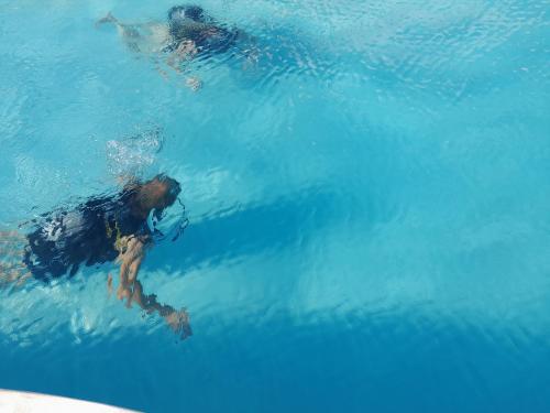 a man riding a wave in a swimming pool at Kijani Beach Villas in Bwejuu