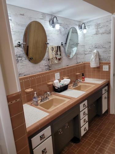 a bathroom with two sinks and two mirrors at dock, game room, bar and private river view patio in Toledo