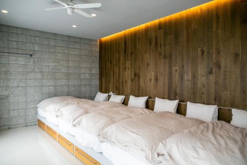 2 camas en un dormitorio con pared de madera en vivid terrace - Vacation STAY 14828v, en Isla Miyako