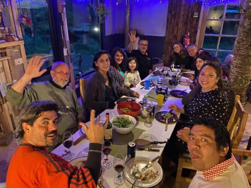 a group of people sitting around a dinner table at La Colmena eco lodge in Ensenada