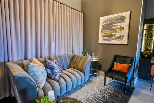 a living room with a couch and a chair at Summer PALACE Guesthouse in Bloemfontein