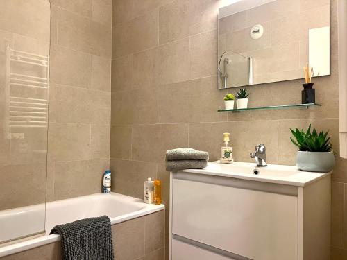 een badkamer met een bad, een wastafel en een spiegel bij Cannes Marina Mandelieu in Mandelieu-la-Napoule