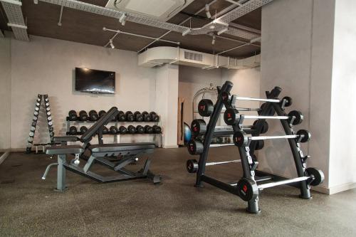 a gym with two rows of weight machines in a room at Wex 1 Apartments in Cape Town