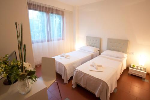 a hotel room with two beds and a window at Lacroma Aparthotel in Grado