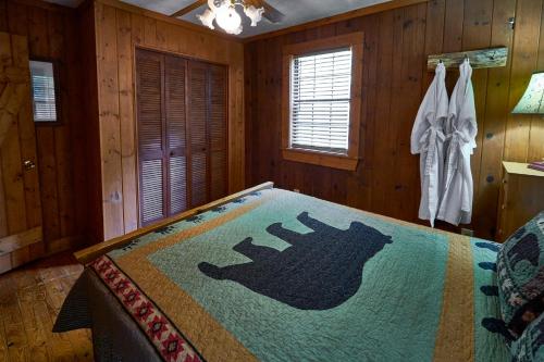 a bedroom with a bed with a blanket on it at A Cabin In The Woods in Pigeon Forge