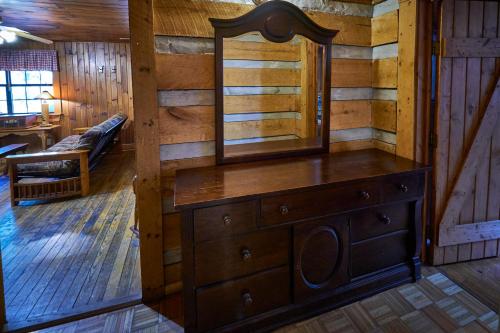 a wooden room with a dresser and a mirror at A Cabin In The Woods in Pigeon Forge