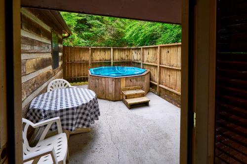a patio with a hot tub and a table and chairs at A Cabin In The Woods in Pigeon Forge