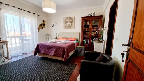 ラゴスにあるQuarto en-suite Casa Cristinaのベッドルーム1室(ベッド1台、椅子、窓付)