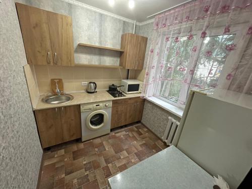 a small kitchen with a sink and a washing machine at 1-комнатная квартира в центре! in Petropavlovsk