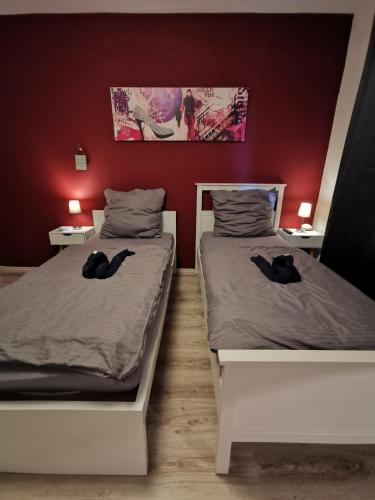 2 Betten in einem Zimmer mit zwei schwarzen Handtüchern darauf in der Unterkunft Liebevoll eingerichtete Ferienwohnung - Zentrale Lage - Netflix & Paytv in Wilhelmshaven