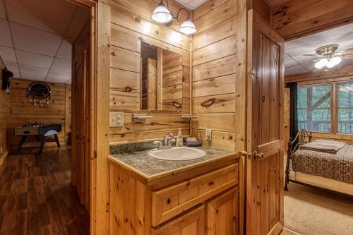 een badkamer met een wastafel in een houten huisje bij Awesome Honey Bear- Get 951 worth of FREE area attraction tickets for each paid day!!! in Sevierville