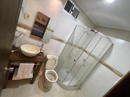 uma casa de banho com um chuveiro, um WC e um lavatório. em Loft & Suites Centro em Salto