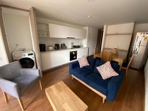 een woonkamer met een blauwe bank en een tafel bij Apartamento Bogota Centro Internacional in Bogota