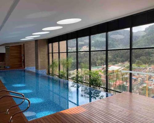 een groot zwembad in een gebouw met ramen bij Apartamento Bogota Centro Internacional in Bogota