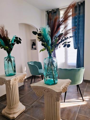 two vases with flowers on a table with chairs at Châtellerie De Schoebeque in Cassel