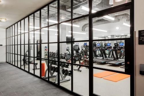 une salle de sport avec des murs en verre et de nombreuses machines à bande de roulement dans l'établissement Canopy By Hilton Boston Downtown, à Boston