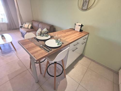 - une cuisine avec une table en bois et 2 assiettes dans l'établissement Superbe appartement avec piscine et stationnement, à Sainte-Maxime