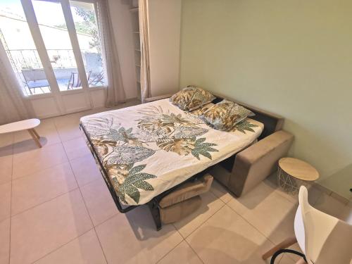 un petit lit dans une chambre avec une fenêtre dans l'établissement Superbe appartement avec piscine et stationnement, à Sainte-Maxime