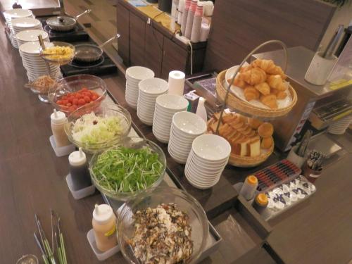 a buffet with plates and bowls of food on a table at Dormy Inn Hakata Gion in Fukuoka