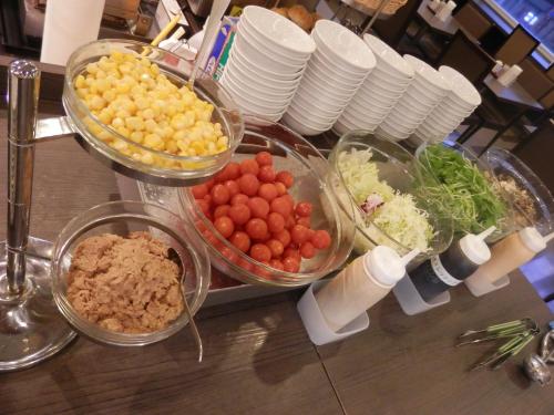 a buffet with bowls of vegetables and other foods at Dormy Inn Hakata Gion in Fukuoka