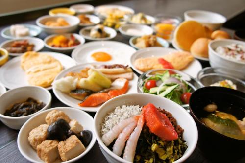 a table topped with bowls of different types of food at Dormy Inn Hakata Gion in Fukuoka