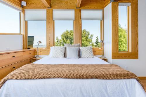 a bedroom with a large bed with two windows at Downtown Oceanview Luxury Home in Anchorage