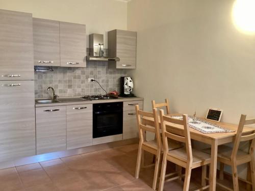 een keuken met een houten tafel met stoelen en een fornuis bij Casale Ciricó tra Catania e Siracusa in Carlentini