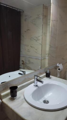 a bathroom with a sink and a mirror at Apartamento Puerta Nueva in Córdoba