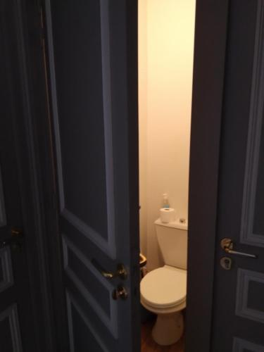 une porte ouverte menant à une salle de bains pourvue de toilettes. dans l'établissement Studio le Métropole Centre ville, à Deauville