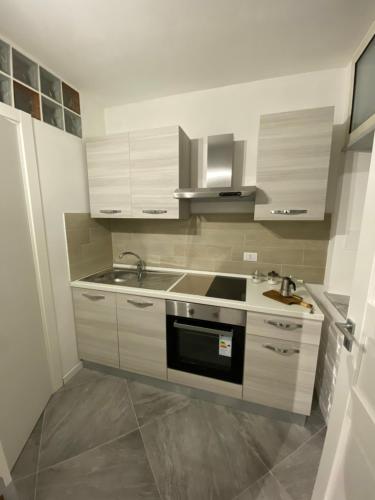 uma cozinha com armários brancos, um lavatório e um fogão em Al Centro di Tutto em Palermo