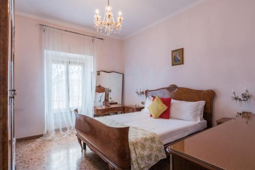 una camera da letto con un letto, una sedia e un lampadario a braccio di Warm apt in ancient building in Vatican-P S Pietro a Roma