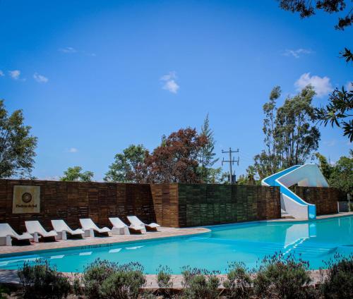 una piscina con sillas y un tobogán en Bodegas Vaivén Hotel Boutique, en Tequisquiapan