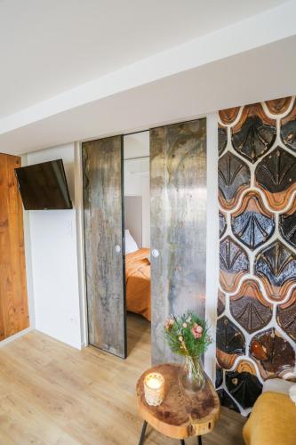 Cette chambre comprend un lit et un vase de fleurs sur une table. dans l'établissement Évasion, à La Capelle-lès-Boulogne