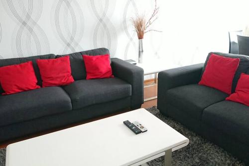 a living room with a black couch and red pillows at Elegante Flat en inmejorable ubicación - San Isidro in Lima