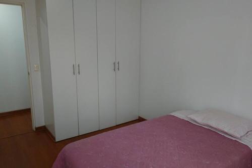 a bedroom with white cabinets and a purple bed at Elegante Flat en inmejorable ubicación - San Isidro in Lima