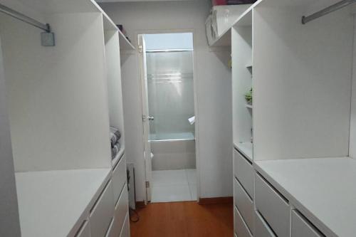 een witte badkamer met een douche en een inloopkast bij Elegante Flat en inmejorable ubicación - San Isidro in Lima